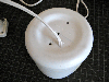 An electrical power cord going into the bottom of a plastic jug.