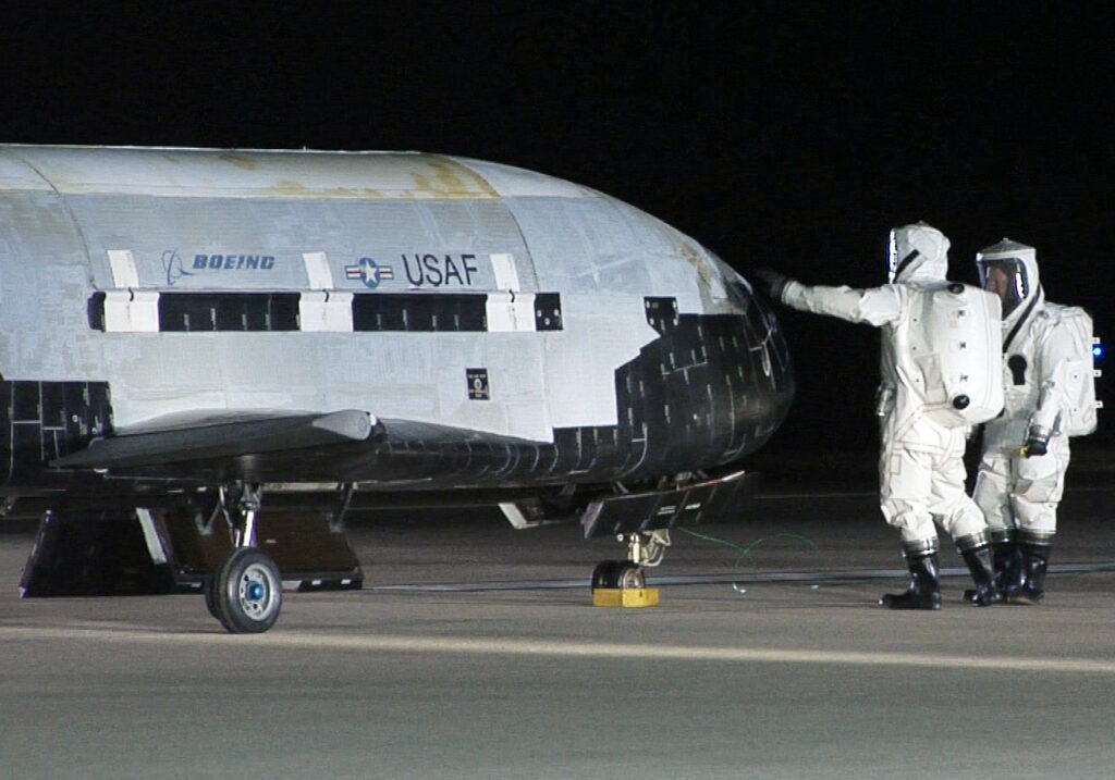 Air Force crews tend to the X-37B secretive space plane after it returned from its maiden voyage Dec. 3, 2010.