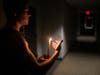 man holding a candle in dark room