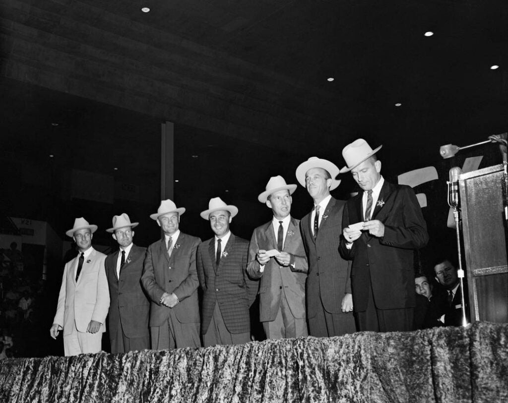 The Mercury Astronauts wearing hats & sheriff stars