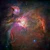The pink-and-orange panorama of the Orion Nebula, which is enveloped by darker, colder gas