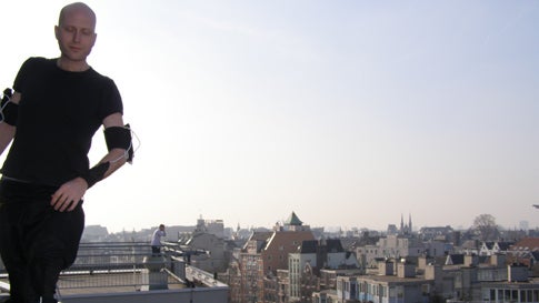Tom Tlalim dancing on a rooftop in Amsterdam, wearing his W_space Wiimote suit.