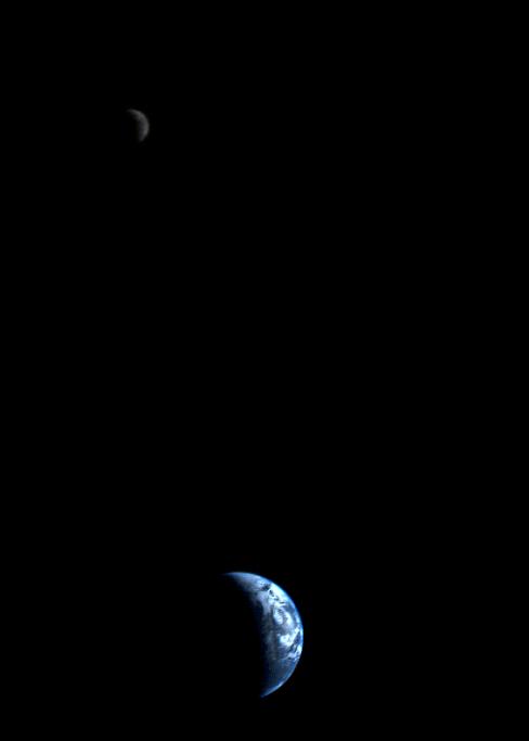 This 1977 image of a crescent-shaped Earth and Moon was the first of its kind ever taken by a spacecraft. The Moon is at the top of the picture and beyond the Earth, as viewed by Voyager 1.