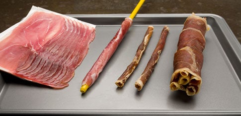 Some slabs of prosciutto, prosciutto wrapped around a fiberglass rod, and dry-baked prosciutto turned into fuel for a thermal lance.