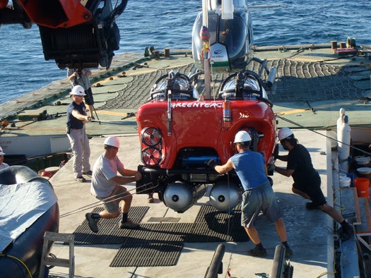 The crew helps guide the sub back onto the deck after a dive. The helicopter I flew in on is visible in the background.