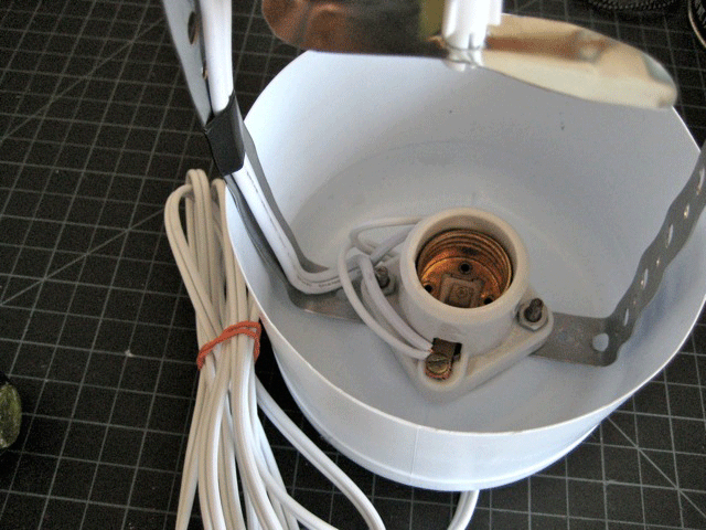 A bracket and bulb socket inside half of a bleach jug.