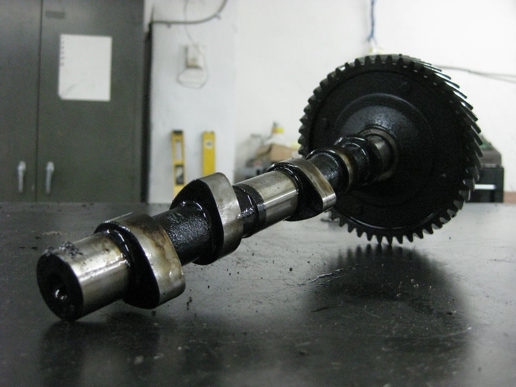 A camshaft controls the timing of valve openings. The cam lobes (the oblong things) push on pushrods (or directly on the valves in an overhead cam engine) to cause the valves to open.