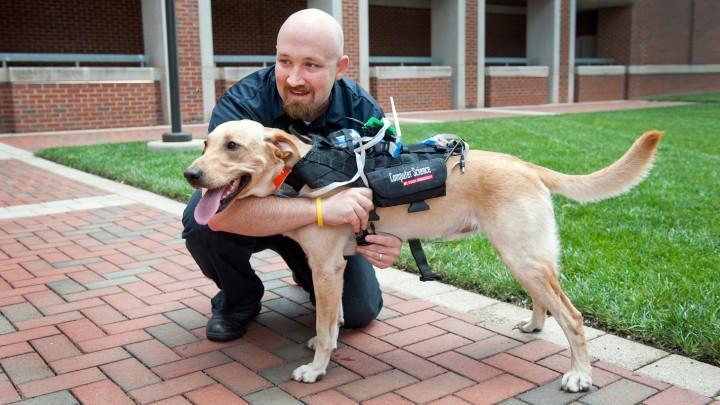 It may sound like the stuff of fiction, but researchers have developed a device aimed at facilitating two-way communication between people and dogs. The device has many practical applications for a wide range of situations – from search and rescue missions to everyday training. One of the research team members is pictured with his <a href="https://www.popsci.com/article/gadgets/high-tech-harness-lets-you-communicate-your-dog/">cyber-canine companion</a>.