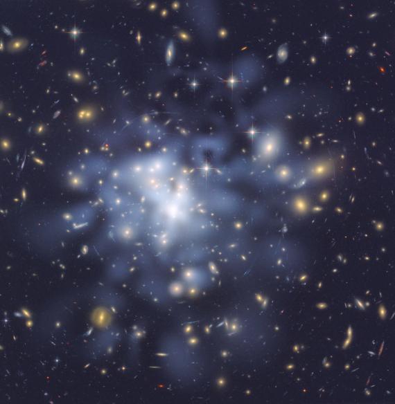 This is one of the most detailed maps of dark matter ever made. The location of the dark matter (tinted blue) was inferred through observations of magnified and distorted distant galaxies seen in this picture.