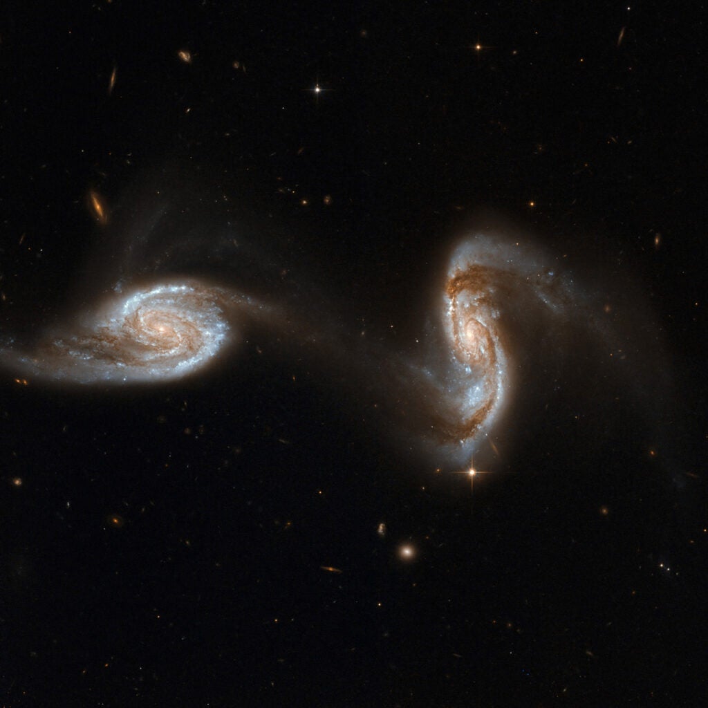 NGC 5257/8 (Arp 240) is an astonishing galaxy pair, composed of spiral galaxies of similar mass and size, NGC 5257 and NGC 5258. The galaxies are visibly interacting with each other via a bridge of dim stars connecting the two galaxies, almost like two dancers holding hands while performing a pirouette. Both galaxies harbor supermassive black holes in their centers and are actively forming new stars in their disks. Arp 240 is located in the constellation Virgo, approximately 300 million light-years away, and is the 240th galaxy in Arp's Atlas of Peculiar Galaxies. With the exception of a few foreground stars from our own Milky Way all the objects in this image are galaxies.