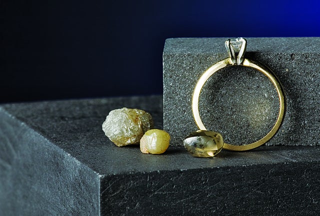 A diamond ring and other gemstones on a graphite block.