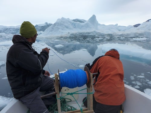 Magnus Petersen and Dave Porter prepare to lower a temperature-depth-salinity sensor into a fjord near the village of Kullorsuaq, as part of a study into changing conditions where Greenland's melting glaciers meet the ocean.