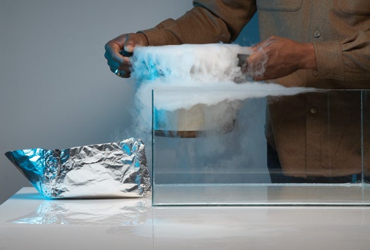 After filling the tank with SF6 gas and pouring dry-ice smoke over it (so that you could see where the layer is), we put a tinfoil boat inside. The gas's high density allows the boat to float on top, making it seem suspended in midair.