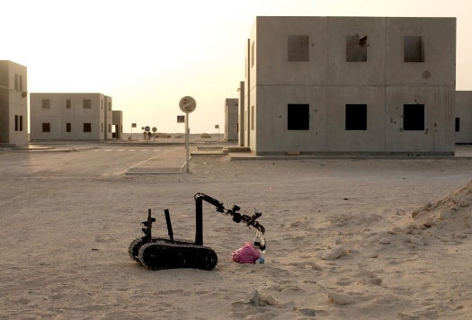 "As you enter a war where you go on 300-400 calls in a one-year rotation, and of those 98 percent of them are live explosive devices, you start leaning more heavily on your robots, and you start giving user feedback to the people that are making those robots," Graves says. Whereas ten years ago your first responder was a EOD tech in a bomb disposal suit, "the go-to guy right now is a robot." The increased reliance on robots for IED disposal has led to a revolution in robot design that otherwise likely would not have happened. As a result, military procurement officers have a buffet of 'bots to choose from these days, and that variety translates to the battlefield. The TALON (pictured above), made by QinetiQ North America, is the biggest robot Navy EOD stacks in the JERRV and it's arguably the workhorse of the bunch. "For me and what I see in most EOD teams, that's usually the robot we prefer," Groat says. "The reason is it's still portable as far as getting it into and out of the truck, but it's got a lot of stronger capabilities. It's got a more stable platform, the arm is a little bit stronger for digging, for carrying heavier charges, the camera system is easy to manipulate and puts out a good video--it's just the one that most EOD techs seem to like when they're driving a mission because you can just do a little bit more." But by no means is the Talon the only robot at Navy EOD's disposal. Platoon 342 also packs two iRobots: a 510 Packbot and the smaller 310 SUGV (Small Unmanned Ground Vehicle). Groat likes the Packbot for the enhanced visibility it offers. Though smaller than the Talon, its camera is mounted on the robot arm itself rather than on a stationary mast, so the operator can extend it upward something like five feet to look over obstacles or vehicles or drop it low to the ground to peer beneath them. For really tight spaces or dismounted operations, Groat and his team turn to the SUGV, a man-portable unit that can be easily packed in a ruck and humped to wherever it's needed. Its low weight means the SUGV is not great for lifting or digging, but everything about it is compact, from its Xbox controller interface to the tiny camera feed monitor, which clips directly onto a pair of Oakleys for a kind of heads-up display. "It's something we've been needing for a while and it's being used pretty heavily out there," Groat says. EOD robots are used for a variety of tasks, but mostly they are deployed to assess potential threats and examine suspected IED sites so no human lives are put in harm's way. And they can even help neutralize IEDs. While the controls are a bit too clumsy for EOD techs to actually dismantle IEDs piece by piece using just the robot arm on the Talon or Packbot, they aren't too clumsy to lay a TNT or C4 charge over the site of an IED and blast it into a harmless crater.