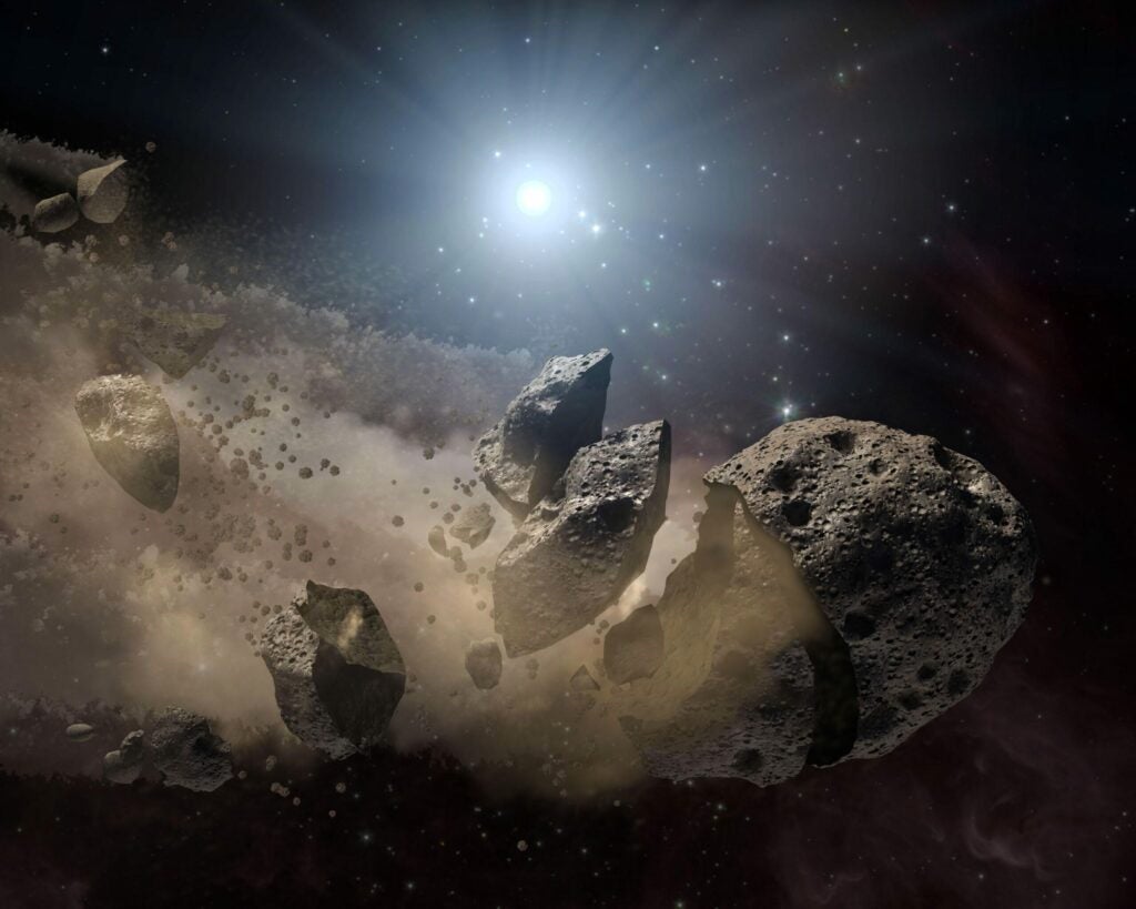 This illustration shows an asteroid breaking up as it orbits a white dwarf.