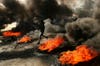 A young man in Bahrain films a tire fire as he runs by. See more amazing photojournalism like this over at <a href="http://www.americanphotomag.com/photo-gallery/2012/03/photojournalism-week-march-23-2012?page=4">American Photo</a>.