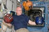 Astronaut Scott Kelly demonstrates small robotic satellites, called SPHERES, that NASA uses for research and for student competitions.