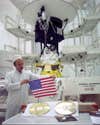 John Casani holding the American flag in front of Voyager 2