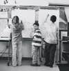 <em>11 a.m. Alex is standing at the board with two of his fourth-grade classmates.</em>