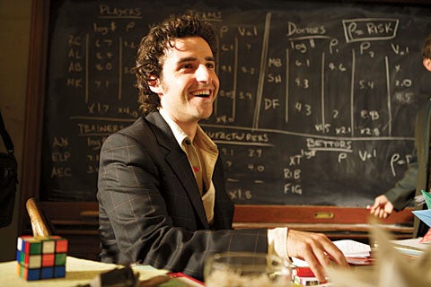 David Krumholtz, who plays genius Charlie Eppes, in front of a series of Sabermetric equations, used to analyze baseball stats.