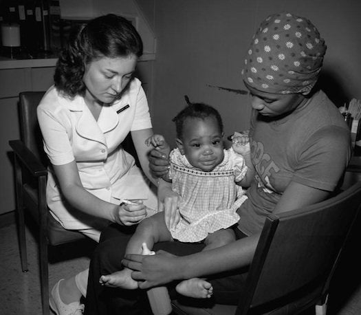 An infant gets a vaccination in the thigh, Dekalb County, Georgia, 1977