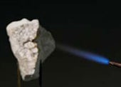 The blue flame of a blowtorch heating up a block of quicklime.