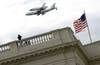 A closer shot of the shuttle zooming over the Capitol building.