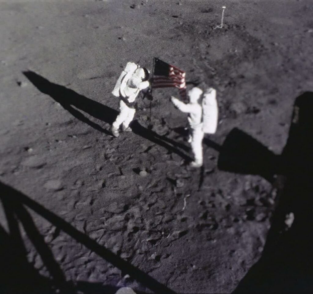 photo of Buzz Aldrin and Neil Armstrong on the surface of the moon, planting a U.S. flag