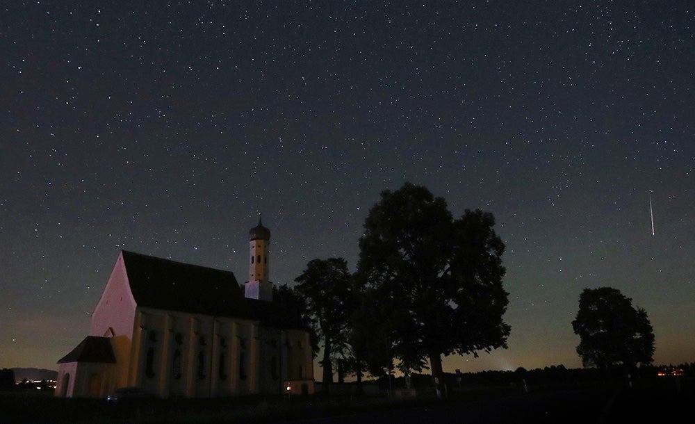 meteor falling over Sankt Coloman church in Germany at night