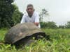 Ranger Fausto Llerena Sánchez poses with a tortoise representing the species that was named in his honor.