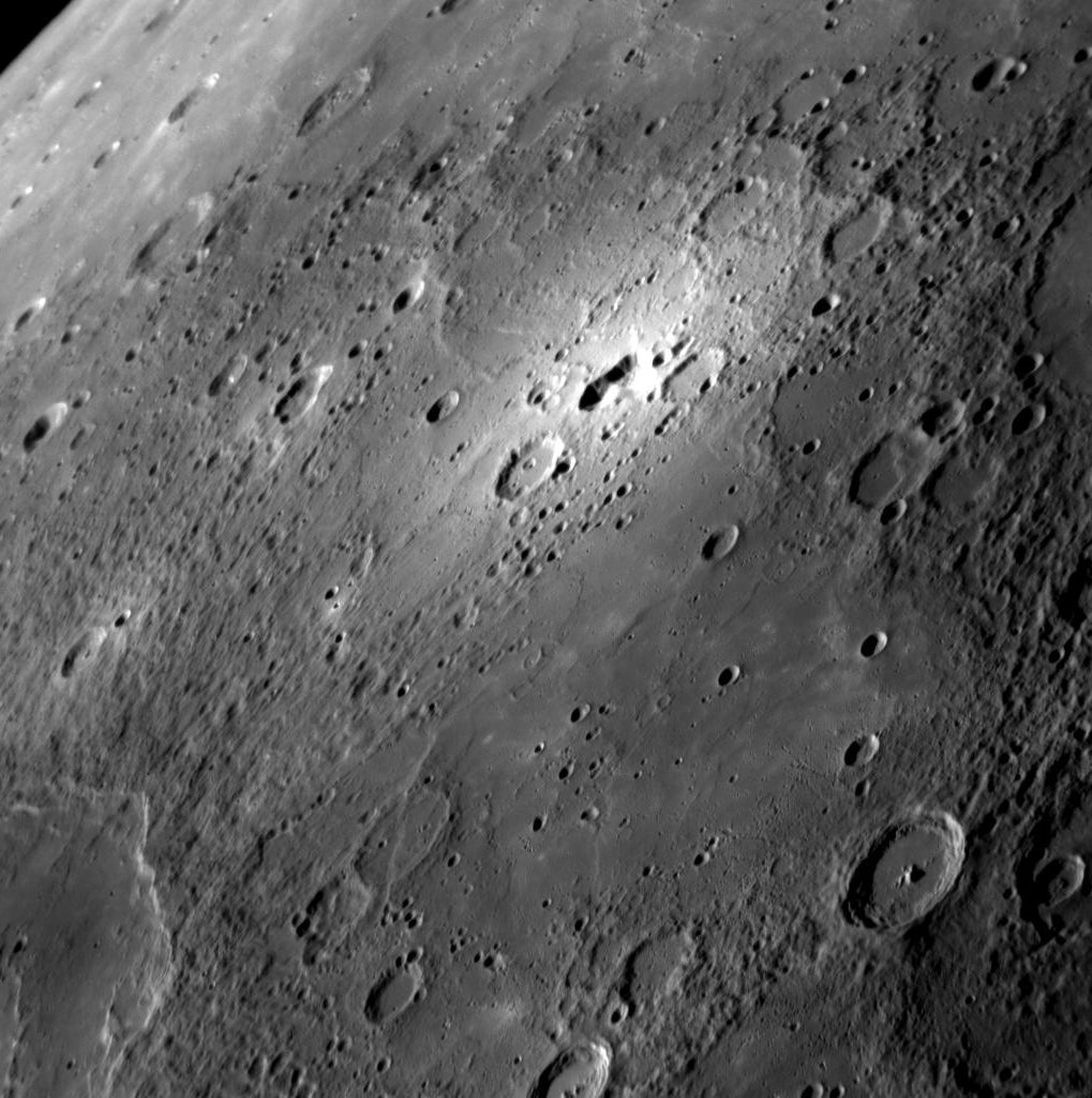 <em>Messenger</em>'s third fly-by has provided the best view so far of the bright area shown near the top center of this image. It allows us to see the feature and its surroundings in greater detail, including the smooth plains in the foreground and the rim of a newly discovered impact basin at its lower left. At the center of the bright halo is an irregular depression, which may have formed through volcanic processes. This area will be of particular interest for further observation during Messenger's orbital operations starting in 2011.