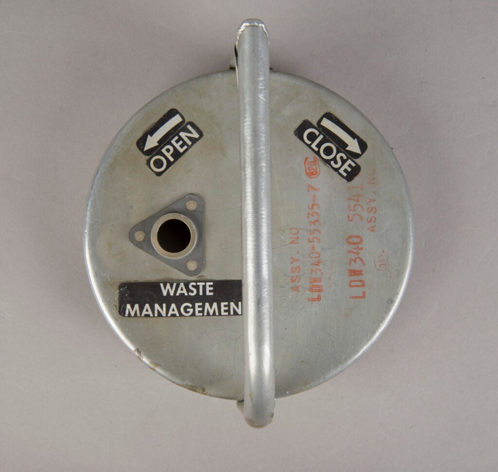 photo of a round metal cover with a handle and "open" and "close" markings