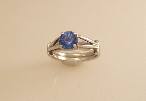 A platinum engagement ring with a lab-grown sapphire in it.