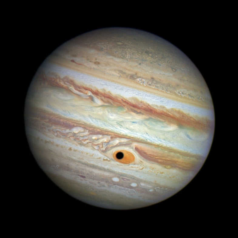 The shadow of the Jovian moon Ganymede as it <a href="https://www.popsci.com/article/technology/big-pic-jupiter-gets-eye-its-storm/">sweeps across</a> Jupiter's Great Red Spot.