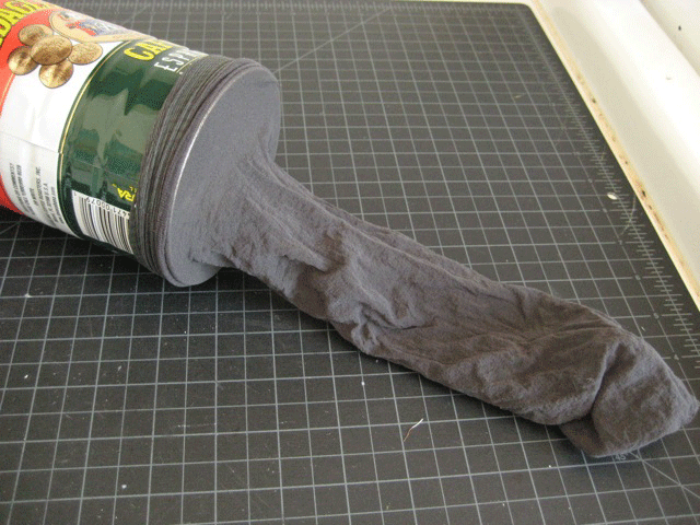 A coffee can with gray pantyhose over one end.