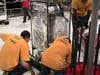 A few high school students with a homemade robot in an arena at the 2009 FIRST Robotics Competition in New York City.