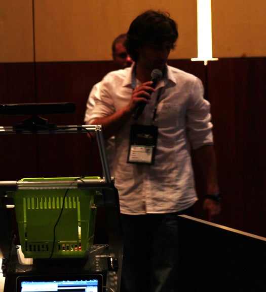A member of Portugal's Team wi-GO demonstrates how their Kinect-enabled shopping cart follows users around.