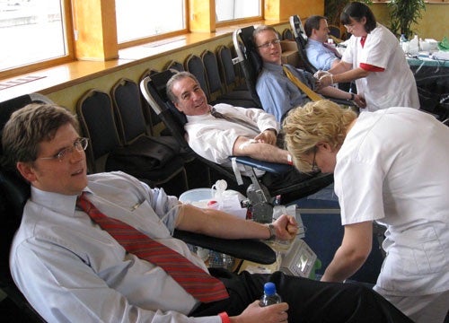 photo of four men donating blood
