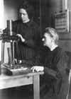 marie curie and her daughter work in a lab