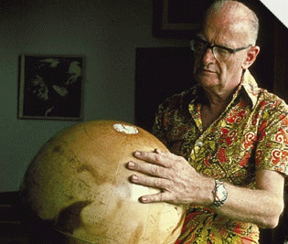 An old man looking at a vintage globe