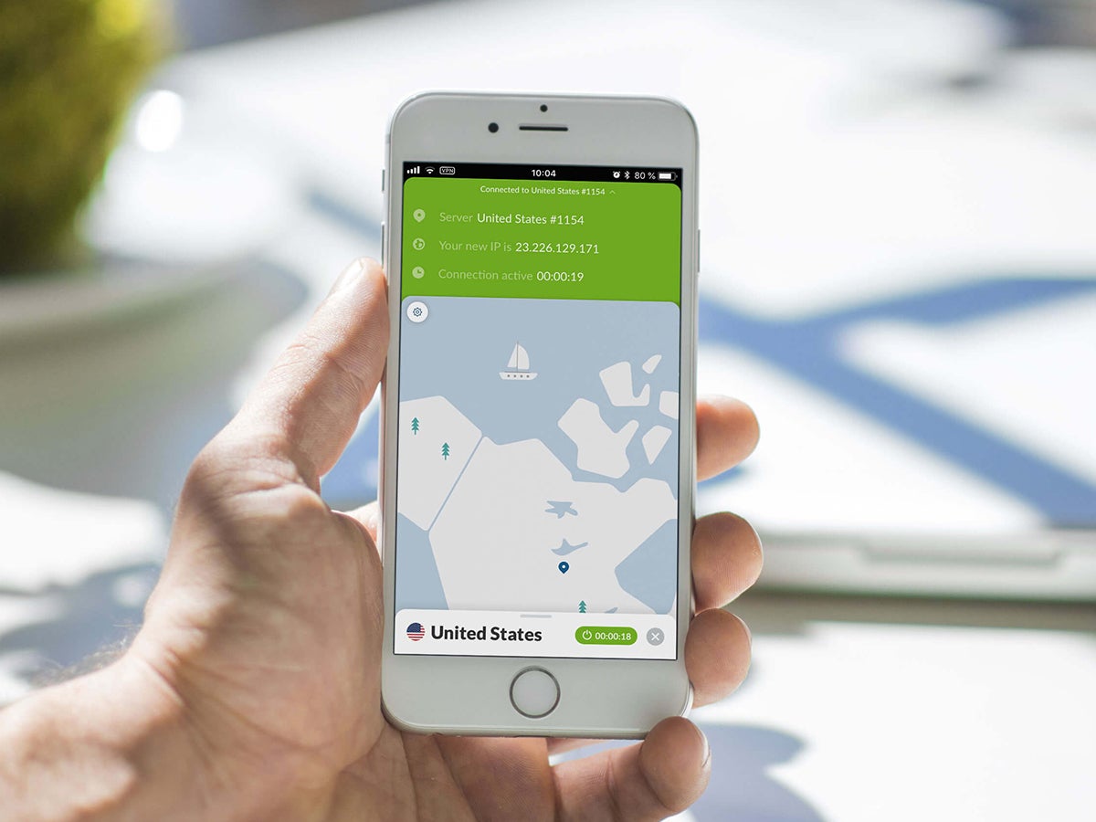 A person holding an iPhone displaying NordVPN for iOS.