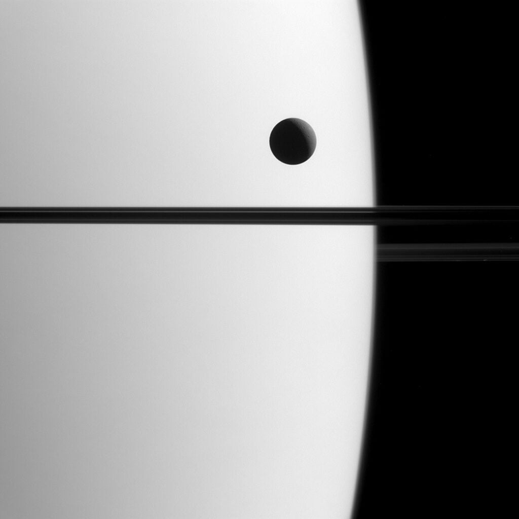 The Cassini spacecraft captured this near perfect example of a transit this past May. A transit occurs when one celestial body moves in front of another celestial body. This particular transit occurred as Saturn’s moon Dione crossed in front of the planet. Scientists use transits to accurately determine the orbital parameters of Saturn’s moons.