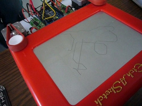 A hands-free Etch A Sketch with a scribble drawn on it.