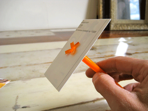 A straw attached to a piece of paper.