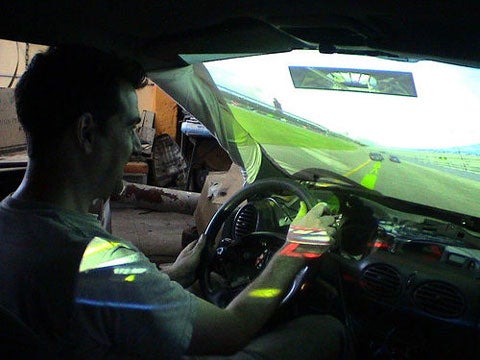 A man inside a driving simulator inside a real car.