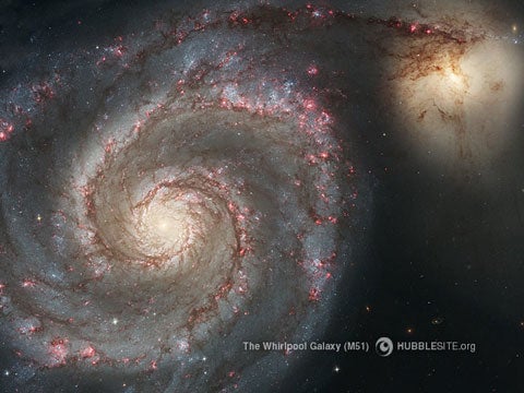The large Whirlpool Galaxy [left] is known for its sharply defined spiral arms. Their prominence could be the result of the Whirlpool's gravitational tug-of-war with its smaller companion galaxy [right].