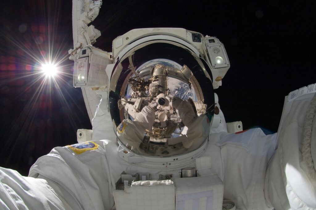 an astronaut takes a selfie in space