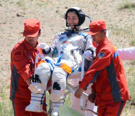 China's first female astronaut, 33-year-old Liu Yang (C), gets carried by two retrieval crew members after she emerged from the charred returned capsule of the Shenzhou-9 spacecraft, which means "divine vessel" in Chinese, in a remote area of northern China on June 29, 2012, after a 13-day mission to an orbiting module that is a prototype for a future space station. Three Chinese astronauts returned to Earth after achieving China's most complex and longest operations in orbit, major steps forward in the country's effort to build a space station by 2020. CHINA OUT AFP PHOTO (Photo credit should read STR/AFP/GettyImages)