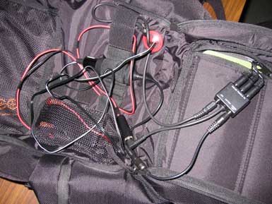 Multiple red and black wires coming out of a black backpack.