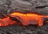 Lava breaks through the cooling crust to continue the formation of a new tributary. Most shield volcanoes, including Kilauea, erupt low-silicon basalt, which results in a more fluid lava.